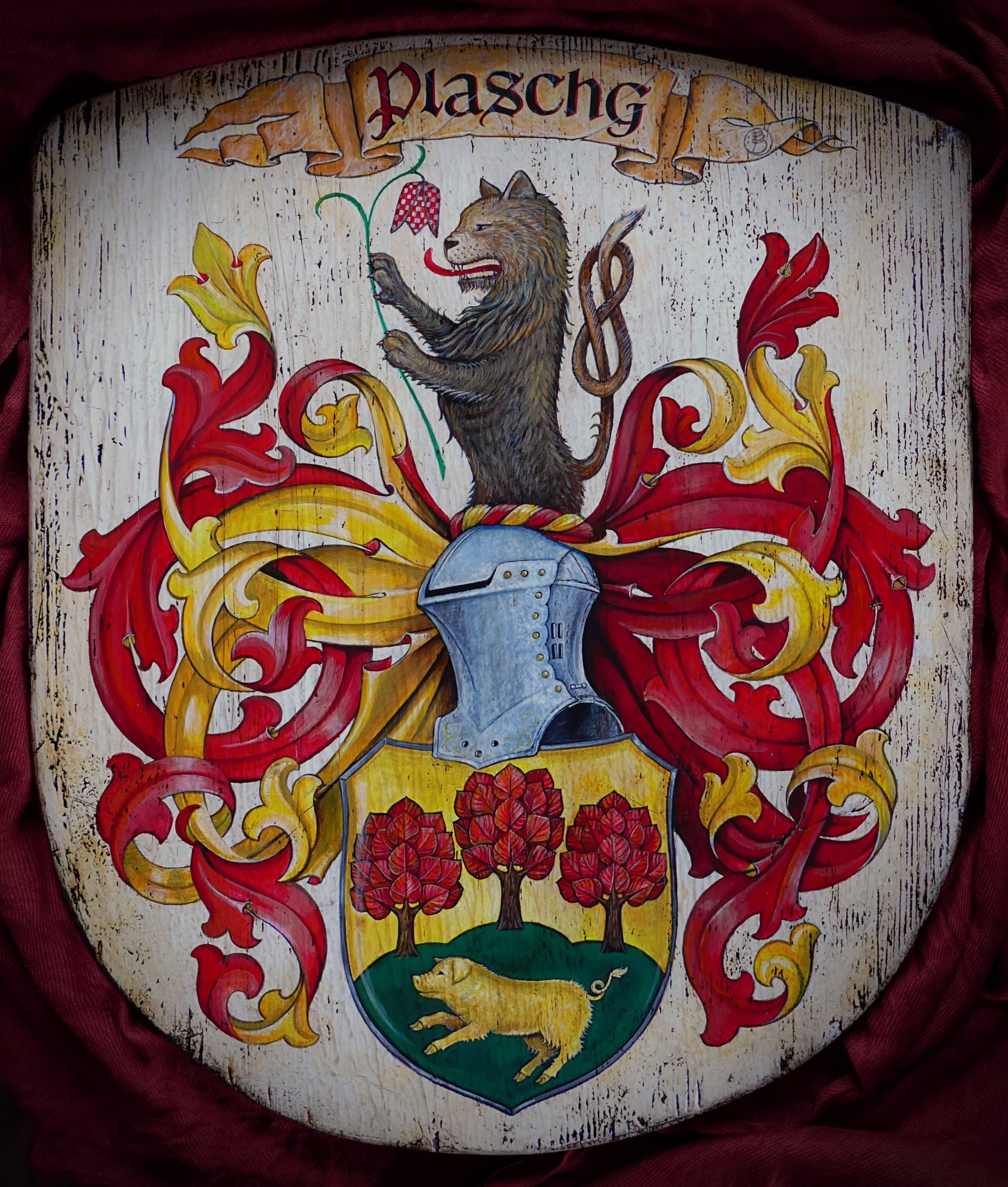 Hand-painted 'Plaschg' family coat of arms with a rearing wolf crest and a shield showing three red trees above a boar
